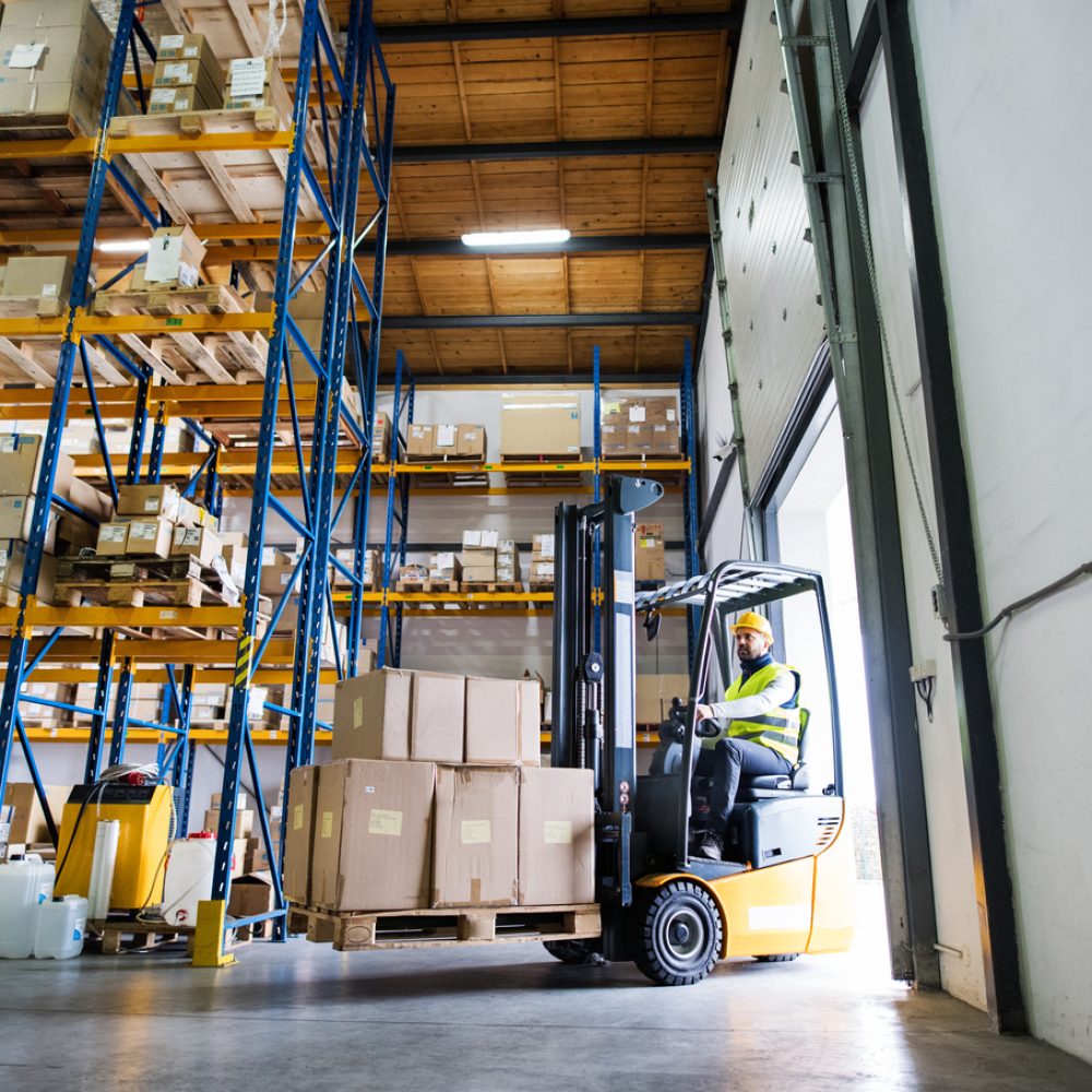 Man forklift driver working in a warehouse.